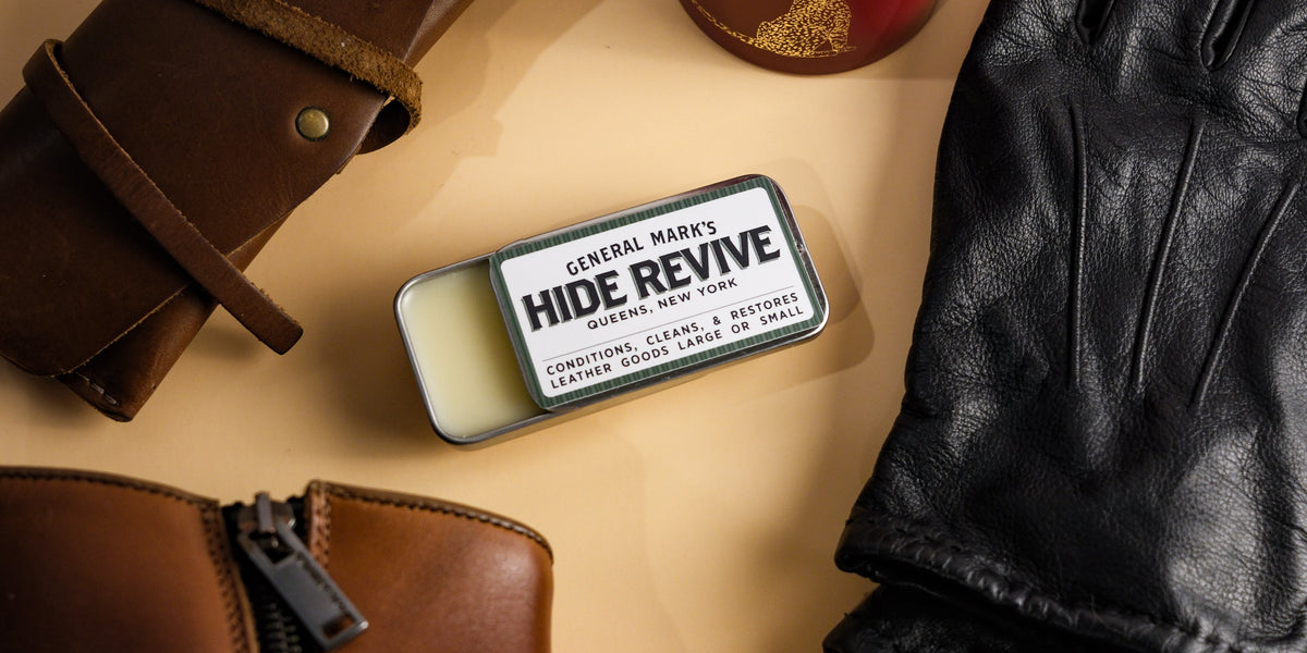 Hide Revive leather conditioner tin among a leather boot, leather roll and black leather gloves